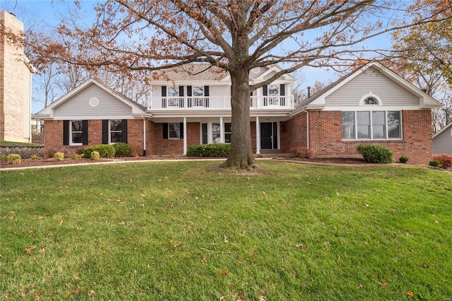 view of front property with a balcony and a front lawn