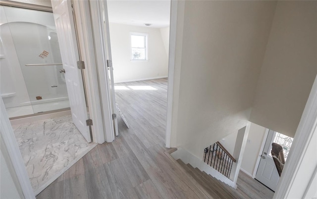 corridor with baseboards and wood finished floors