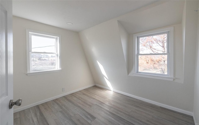 unfurnished room featuring a wealth of natural light, baseboards, and wood finished floors