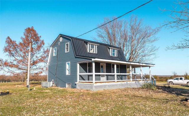 colonial inspired home with a gambrel roof, a front lawn, a porch, central AC, and metal roof