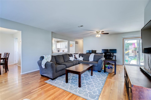 living room featuring ceiling fan and light hardwood / wood-style flooring