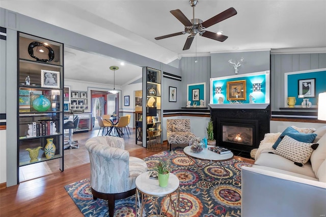 living room featuring hardwood / wood-style flooring, vaulted ceiling, and crown molding