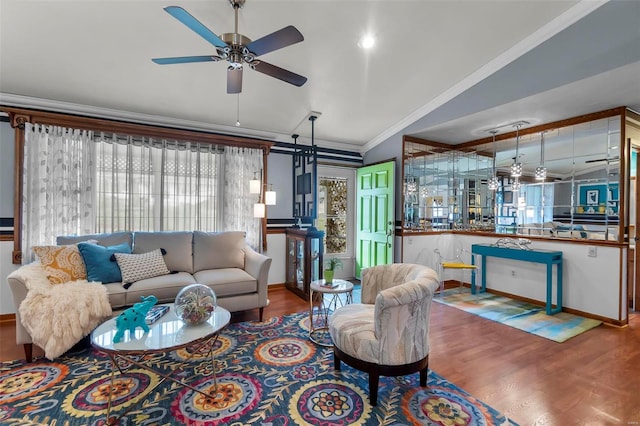 living room with ceiling fan, a barn door, hardwood / wood-style floors, vaulted ceiling, and ornamental molding