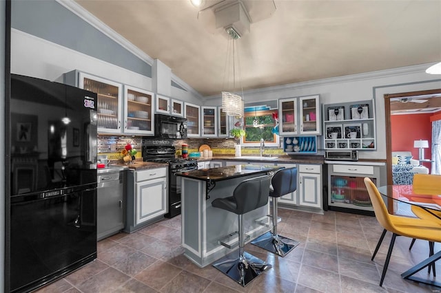 kitchen featuring a center island, sink, pendant lighting, lofted ceiling, and black appliances