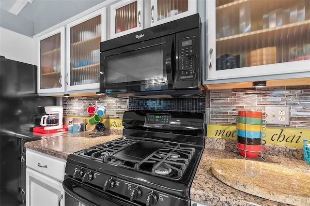 kitchen featuring stone counters, tasteful backsplash, white cabinetry, and black appliances