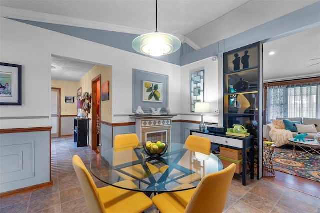 dining space with lofted ceiling and ornamental molding