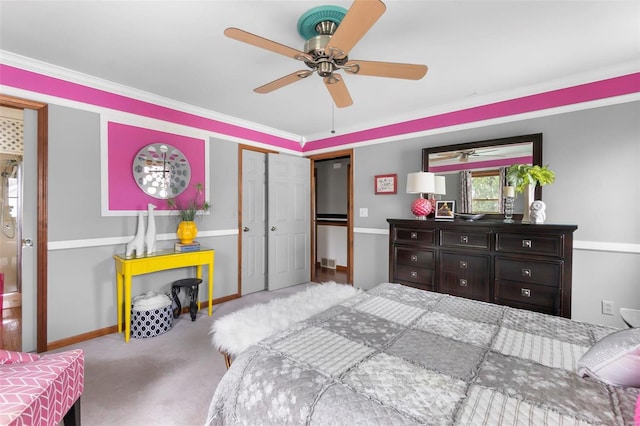 carpeted bedroom with ceiling fan, ornamental molding, and a closet