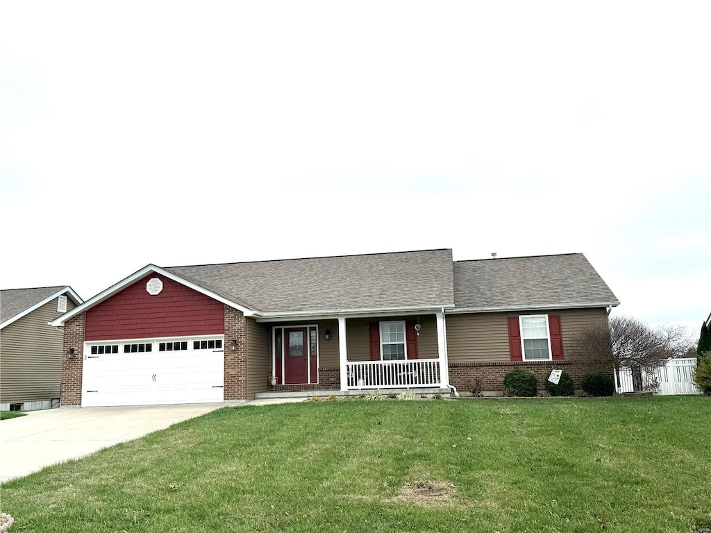 ranch-style house featuring a front yard, a porch, and a garage