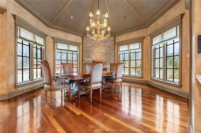 dining area featuring crown molding, a notable chandelier, wooden ceiling, baseboards, and hardwood / wood-style flooring