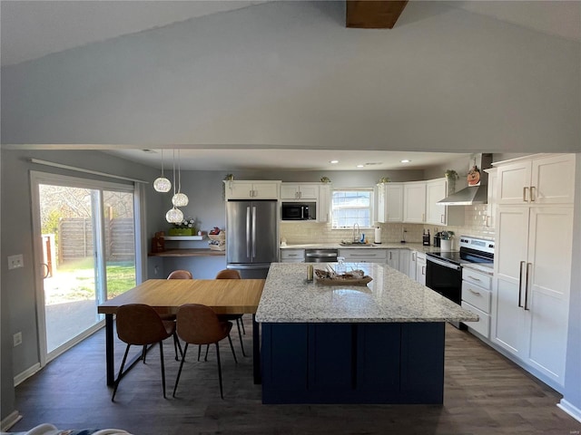 kitchen featuring wall chimney exhaust hood, stainless steel appliances, dark wood-type flooring, sink, and decorative light fixtures