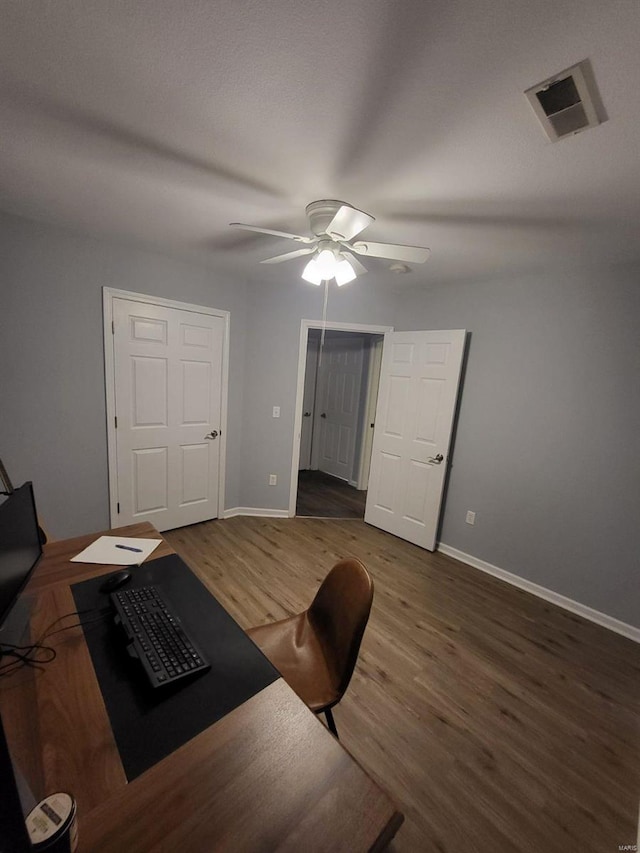 home office featuring ceiling fan and dark wood-type flooring