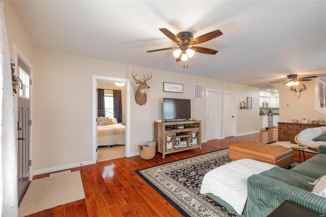 living room with a wealth of natural light, ceiling fan, and wood-type flooring