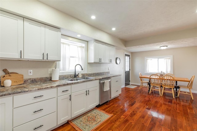 kitchen featuring dishwasher, sink, white cabinets, and dark hardwood / wood-style floors