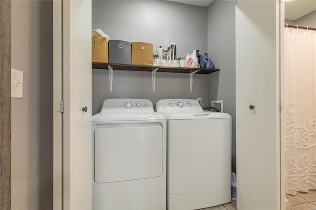 laundry area featuring washing machine and dryer and light tile patterned floors