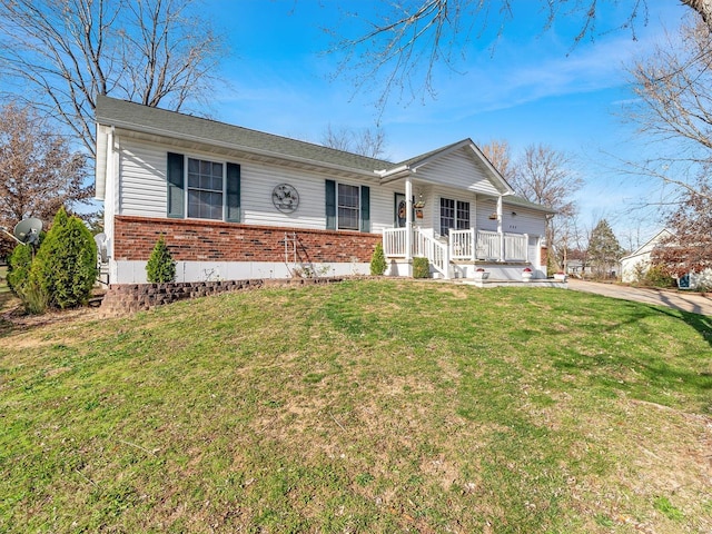 ranch-style house featuring covered porch and a front yard