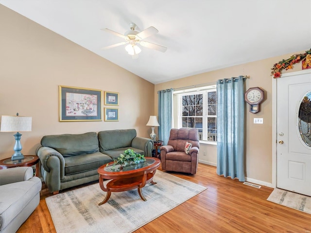 living room with ceiling fan, lofted ceiling, and light wood-type flooring