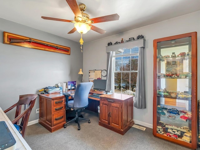 carpeted office space featuring ceiling fan