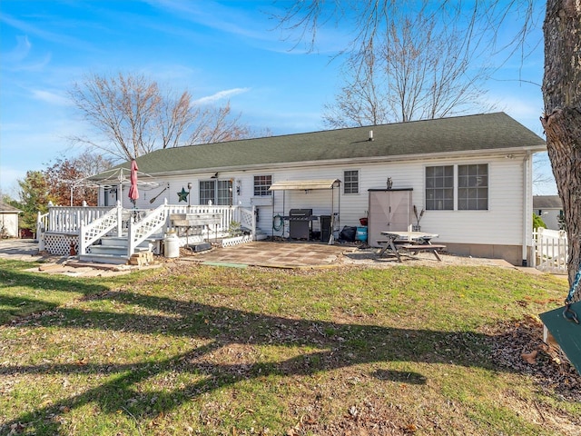 back of property with a patio area, a yard, and a deck