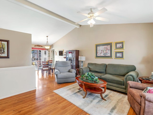 living room with vaulted ceiling with beams, light hardwood / wood-style flooring, and ceiling fan