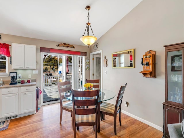 dining space featuring light hardwood / wood-style floors and lofted ceiling