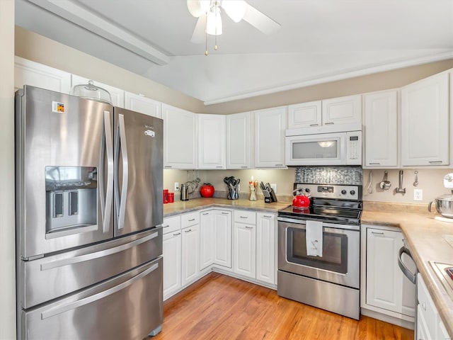 kitchen with white cabinets, vaulted ceiling, ceiling fan, light wood-type flooring, and appliances with stainless steel finishes