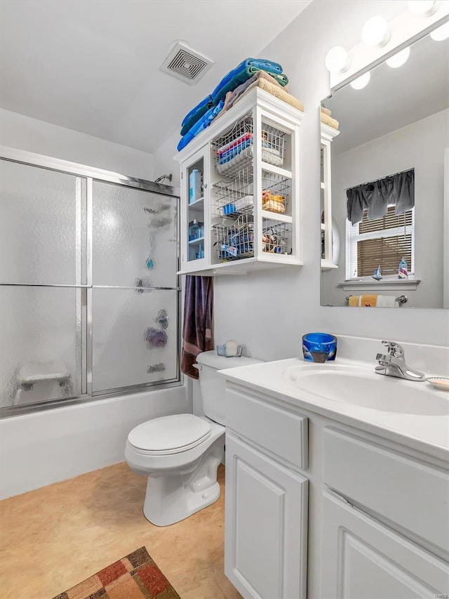 full bathroom featuring vanity, toilet, and bath / shower combo with glass door