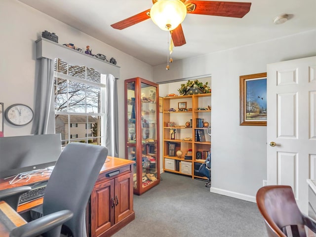 carpeted office space featuring ceiling fan