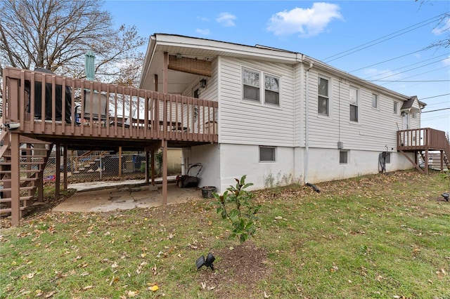 rear view of property featuring a lawn and a deck