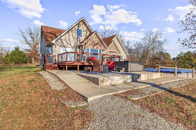 back of house featuring a swimming pool with hot tub