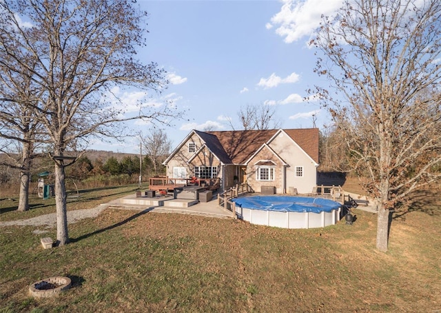 rear view of house featuring a yard and a covered pool