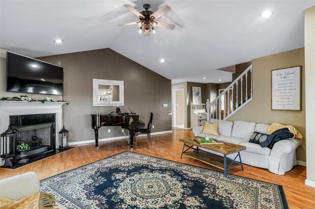 living room with hardwood / wood-style floors, ceiling fan, and lofted ceiling