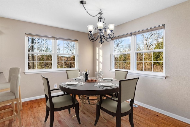 dining room with a chandelier, hardwood / wood-style flooring, and a healthy amount of sunlight