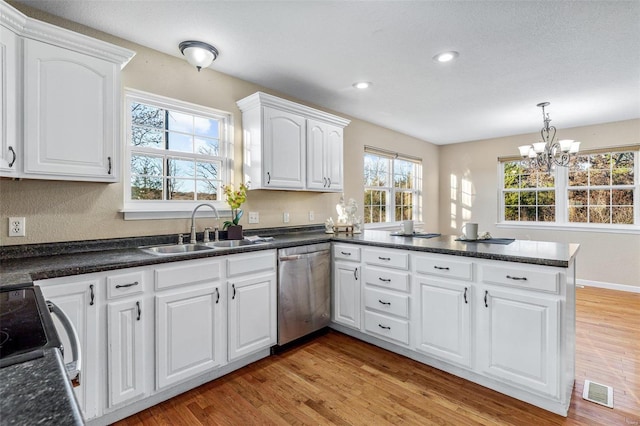 kitchen with kitchen peninsula, white cabinetry, dishwasher, and light hardwood / wood-style flooring