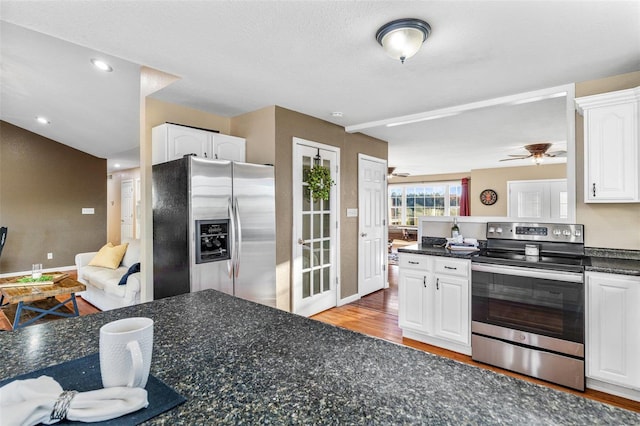 kitchen with light wood-type flooring, a textured ceiling, stainless steel appliances, ceiling fan, and white cabinets