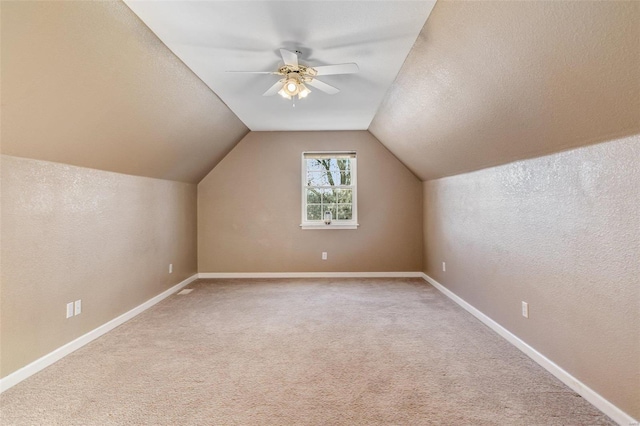 additional living space featuring a textured ceiling, ceiling fan, carpet floors, and vaulted ceiling