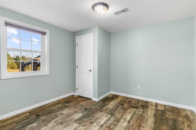 unfurnished bedroom with dark wood-type flooring and a closet