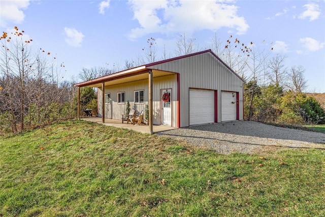 exterior space with a front yard, a porch, a garage, and an outdoor structure