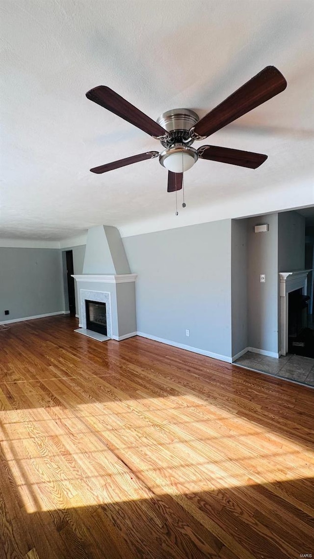 unfurnished living room featuring wood-type flooring, a textured ceiling, and ceiling fan