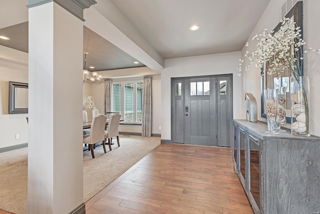 entrance foyer with an inviting chandelier and hardwood / wood-style flooring