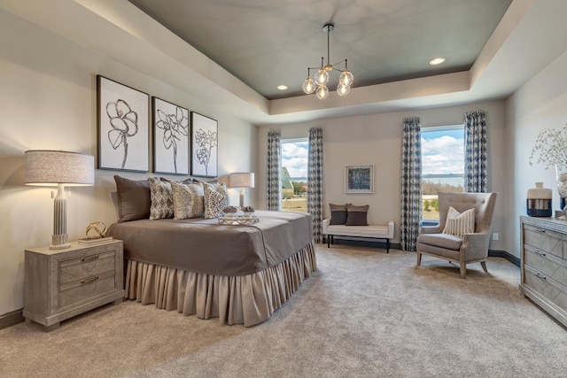 carpeted bedroom featuring a notable chandelier, a raised ceiling, and multiple windows