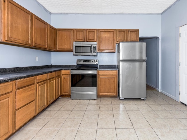 kitchen with light tile patterned flooring and appliances with stainless steel finishes