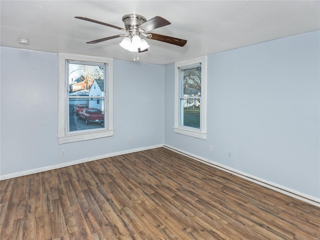 empty room with ceiling fan, dark hardwood / wood-style flooring, and a wealth of natural light