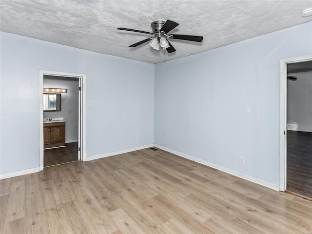 empty room featuring ceiling fan, sink, a textured ceiling, and light wood-type flooring