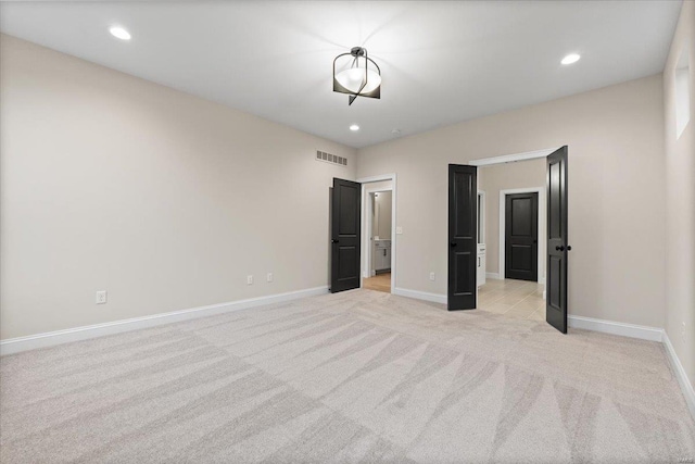 unfurnished bedroom featuring recessed lighting, visible vents, baseboards, and light colored carpet