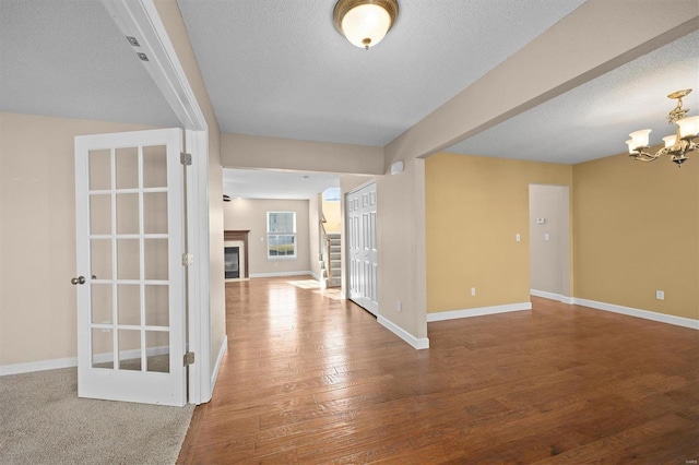 interior space with hardwood / wood-style floors, a textured ceiling, and a chandelier