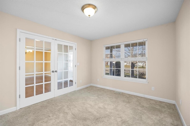 spare room with french doors and light carpet