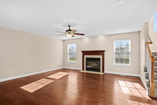 unfurnished living room with ceiling fan, dark wood-type flooring, and a fireplace