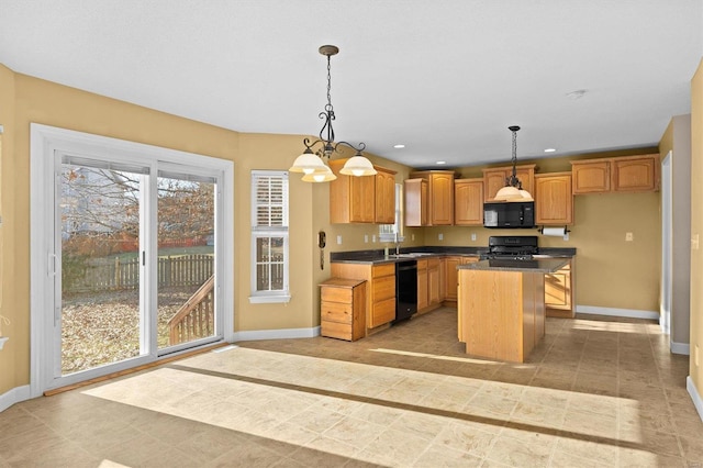 kitchen featuring a kitchen island, pendant lighting, and black appliances