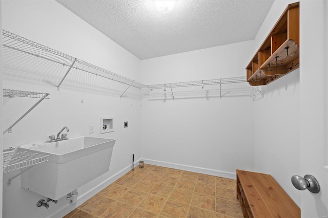 laundry room featuring hookup for an electric dryer, sink, hookup for a washing machine, and a textured ceiling