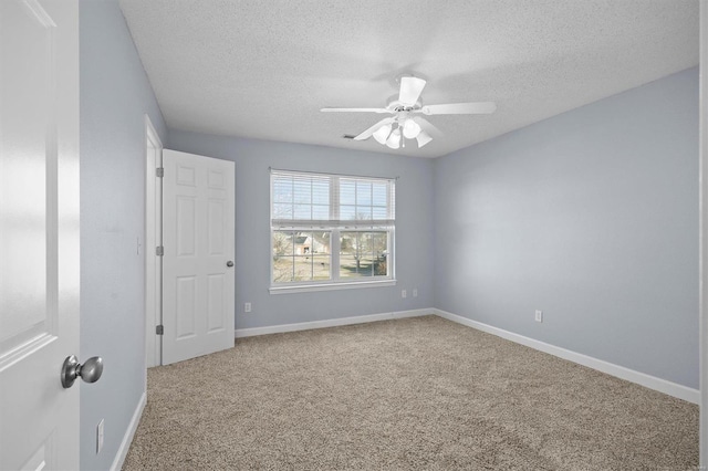 spare room featuring ceiling fan, carpet, and a textured ceiling